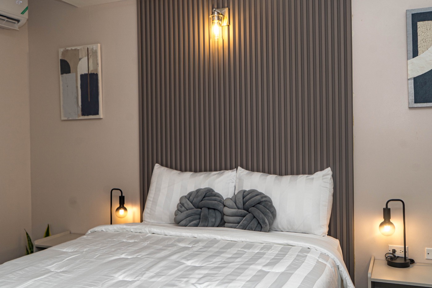 Bedroom from another angle with wall sconce and artwork