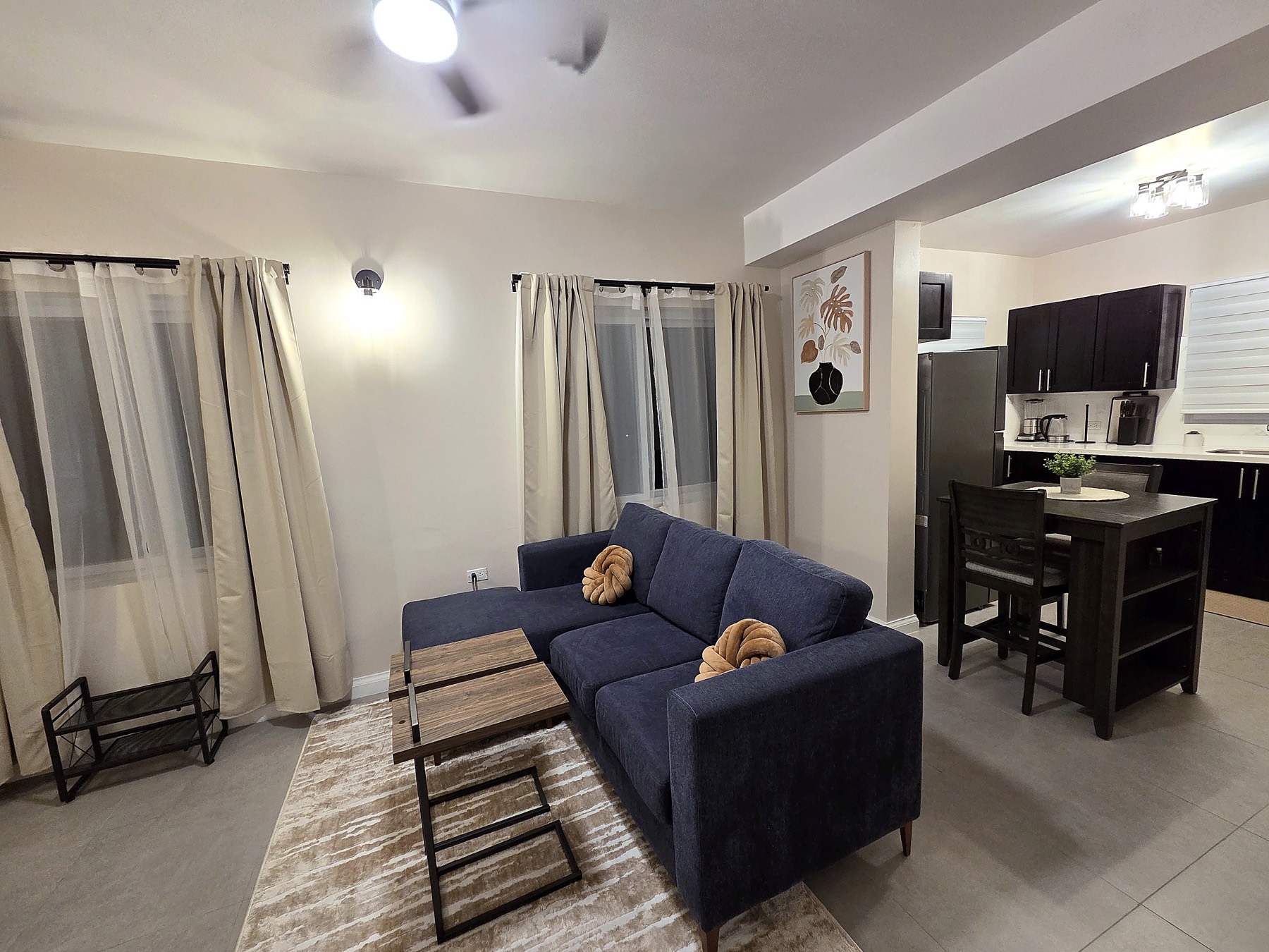 Open-plan living room and kitchen at Abia, lit warmly in the evening