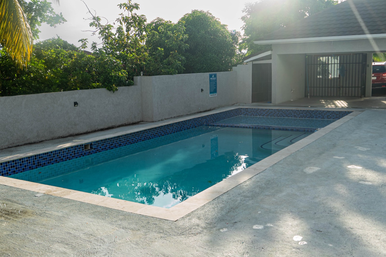 Pool deck and gated grounds in afternoon light